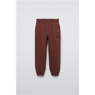 TROUSERS WITH EMBROIDERED SLOGAN