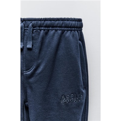 TROUSERS WITH EMBROIDERED SLOGAN