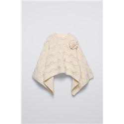 CABLE-KNIT CAPE WITH FLOWER