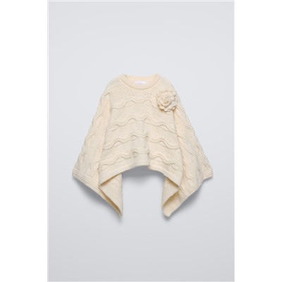 CABLE-KNIT CAPE WITH FLOWER